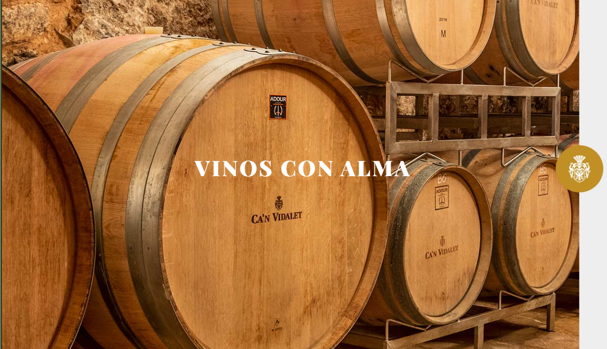 Barricas de roble con el sello de la bodega Can Vidalet alineadas en la sala de envejecimiento, simbolizando la elaboración artesanal de vinos con alma en Mallorca. La imagen transmite el equilibrio entre tradición, tiempo y pasión que define a los vinos mallorquines de Can Vidalet, envejecidos cuidadosamente para alcanzar su máxima expresión.