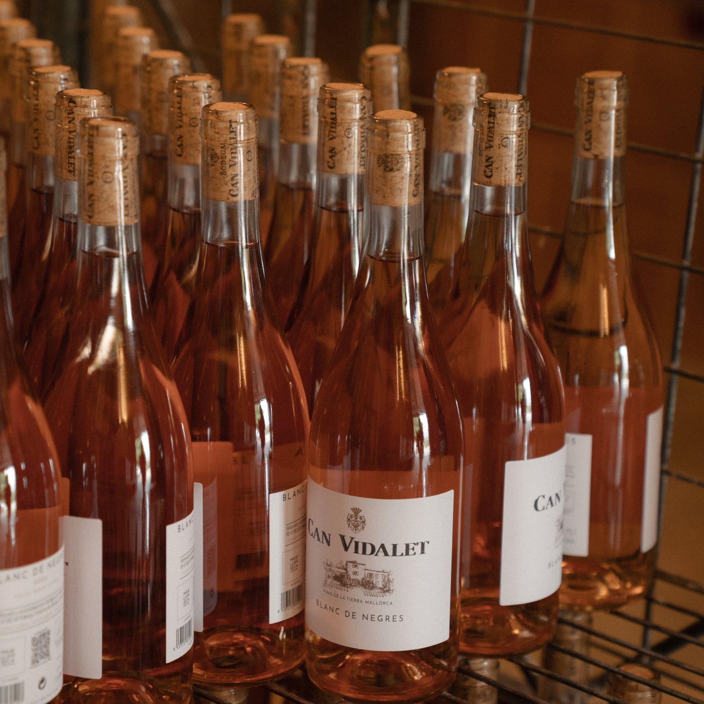 Filas de botellas de Blanc de Negres de Can Vidalet listas en la bodega. Vino rosado ecológico elaborado en Pollença, Mallorca, en el corazón de la Serra de Tramuntana.