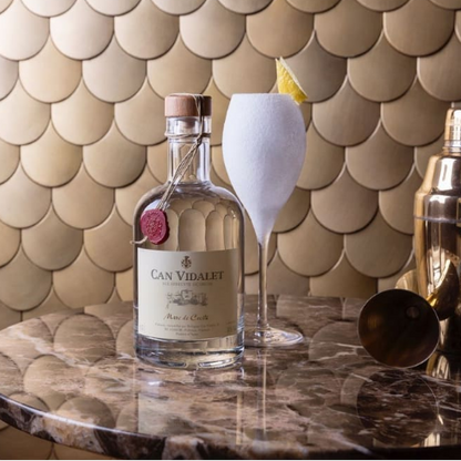 Marc de Cecili de Can Vidalet acompañado de un cóctel refrescante; una experiencia elegante que combina tradición mallorquina y mixología moderna.