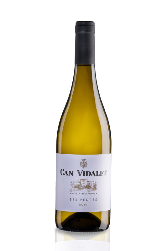 Una botella verde, con etiqueta blanca y capa negra, contiene un vino blanco de color dorada, un Ses Pedres 2019 de las tierras de Mallorca, Bodegas Can Vidalet.